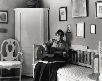 Fotografi. Berta Edelfelt med sin gitarr i villan i Haiko. Borgå Museum.